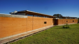 estudio-piloti-casa-cunha-fachada-parede-taipa-cobertura-telha-metalica