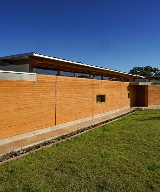 estudio-piloti-casa-cunha-fachada-parede-taipa-cobertura-telha-metalica